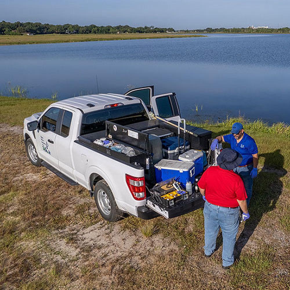 Image of environmental compliance specialists near reservoir.