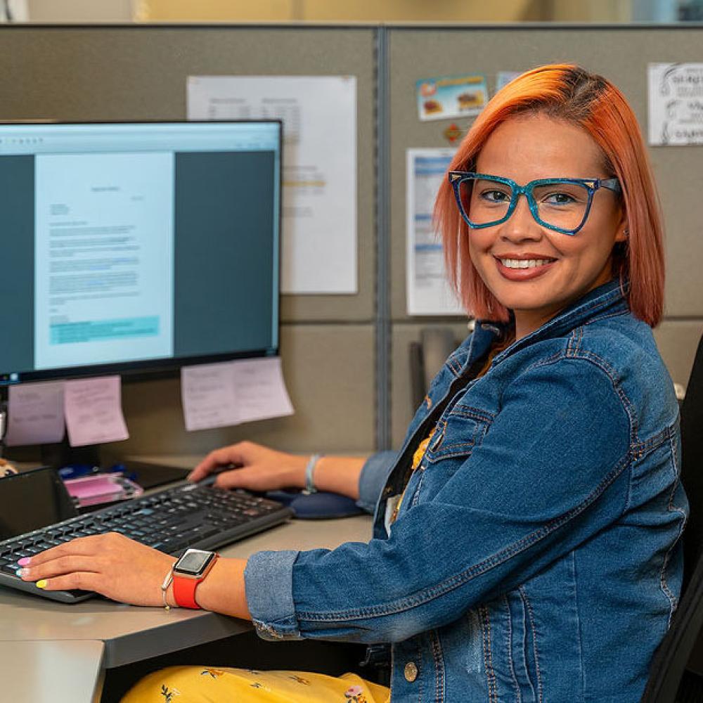 Image of female customer collections representative at her desk. 