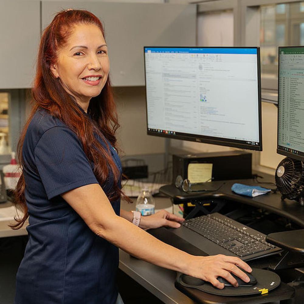 Image of female administrative coordinator at her desk. 