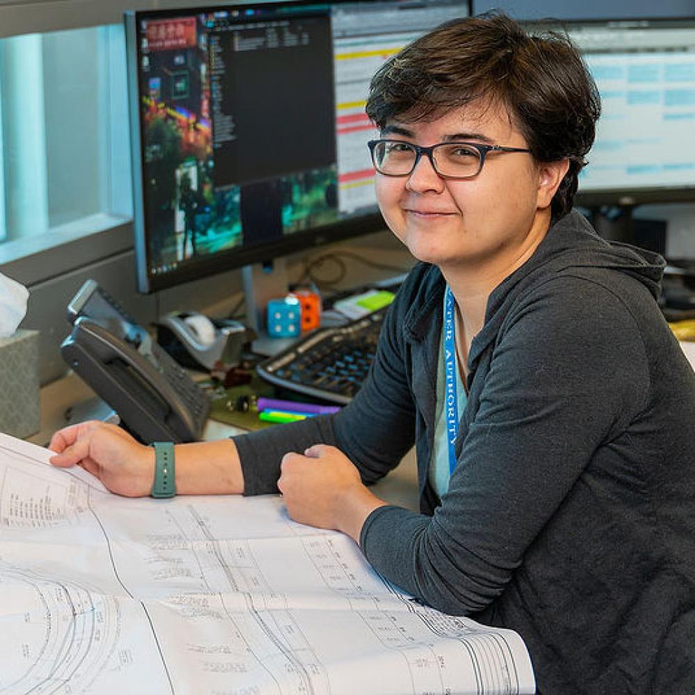 Image of female development project manager at her desk looking at plans.