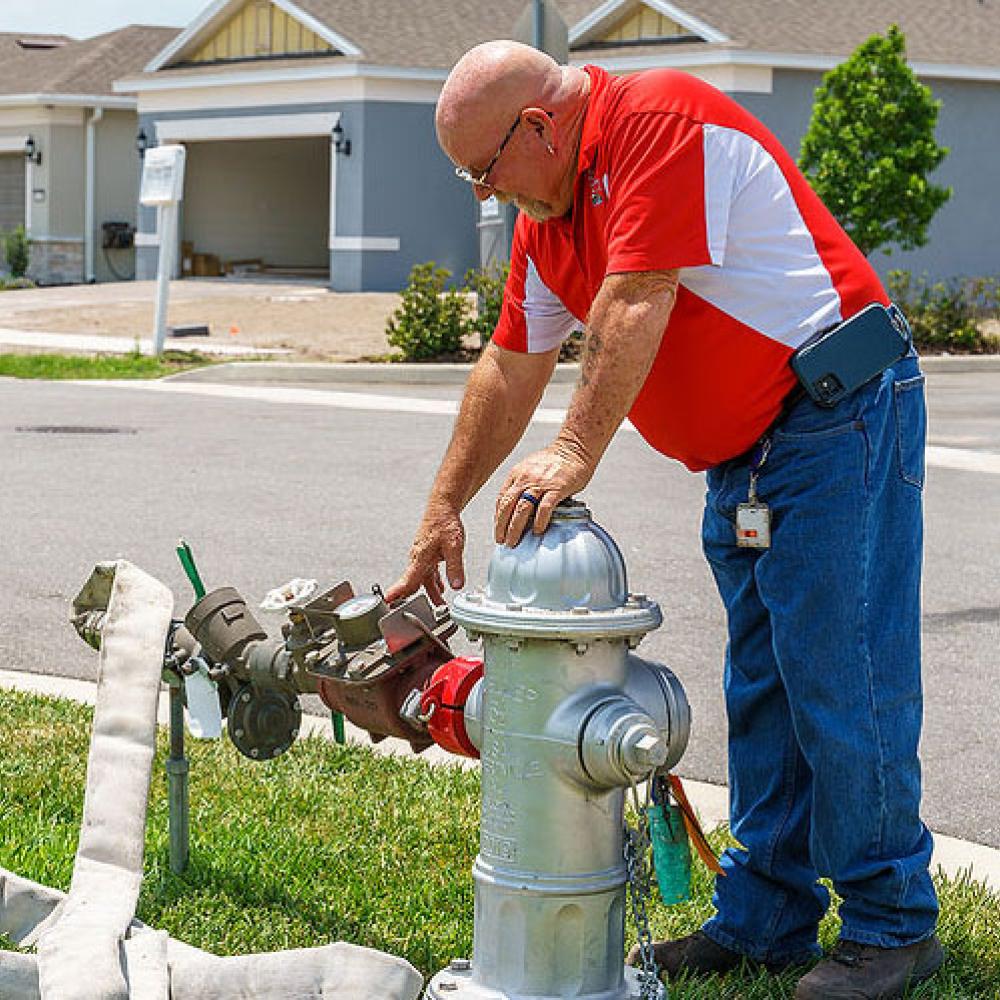 Image of construction inspector looking at hydrant meter. 