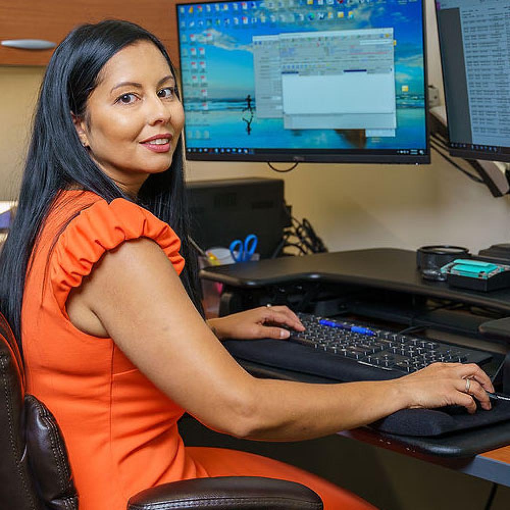 Image of female finance employee sitting at desk. 