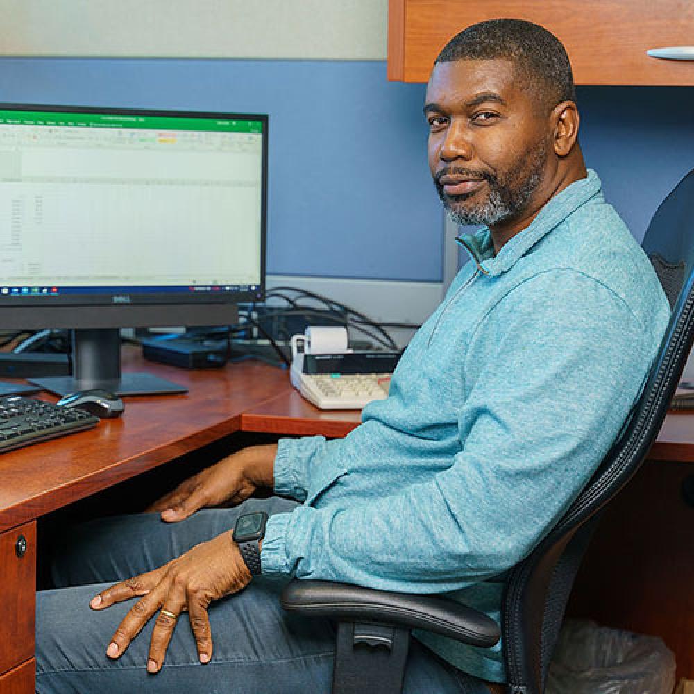 Image of male finance manager sitting at desk. 