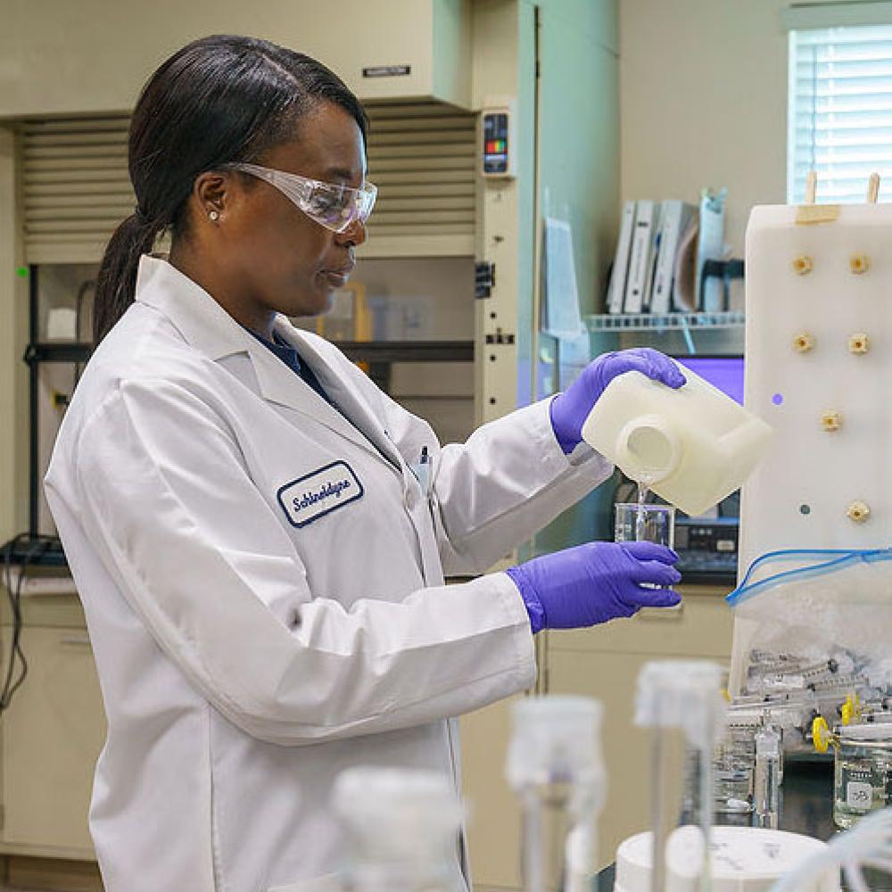 Image of lady as a lab technician conducting test.