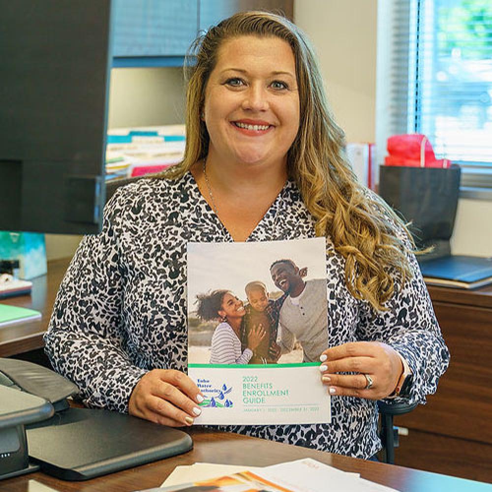 Image of HR generalist holding benefits book. 