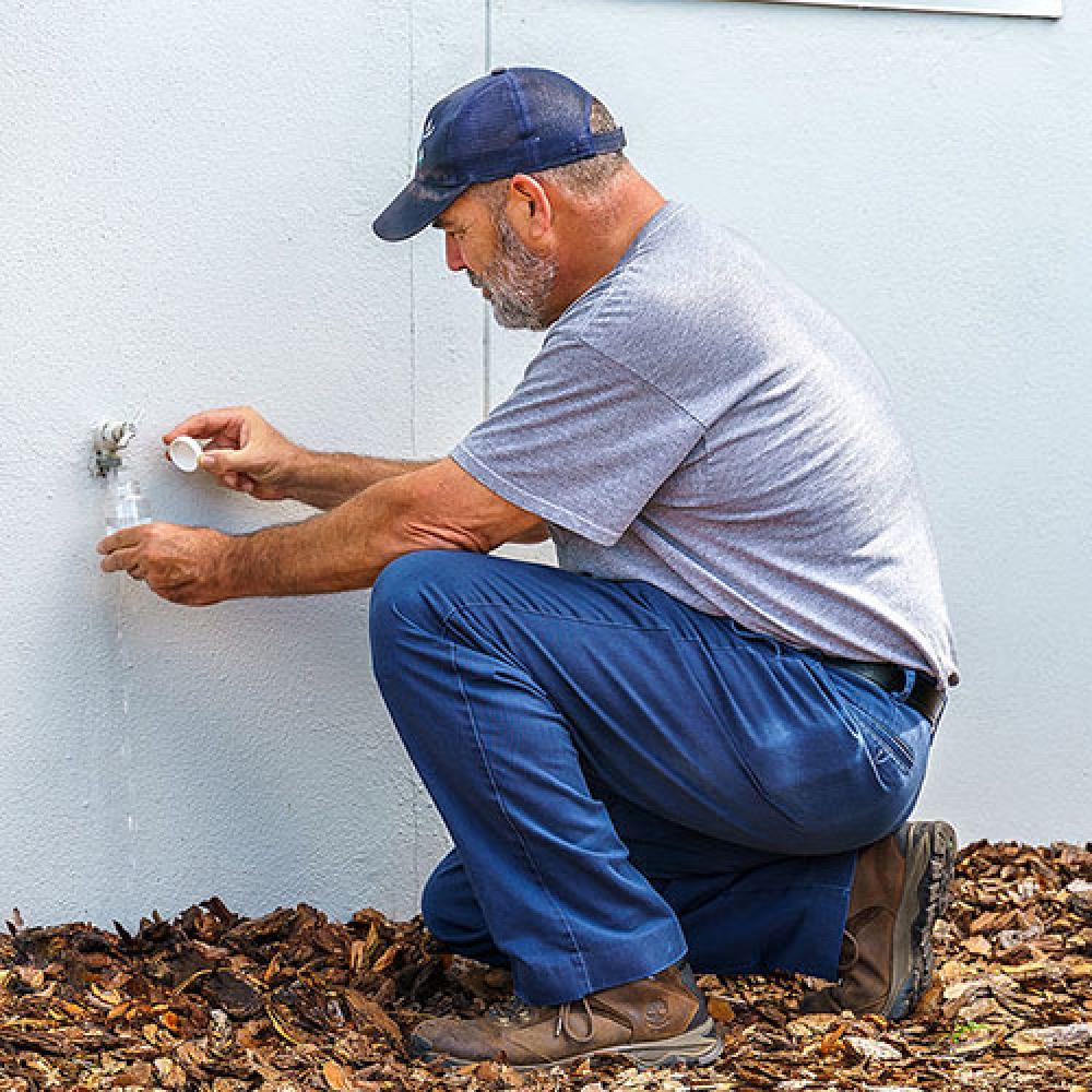 Image of technician taking water sample.