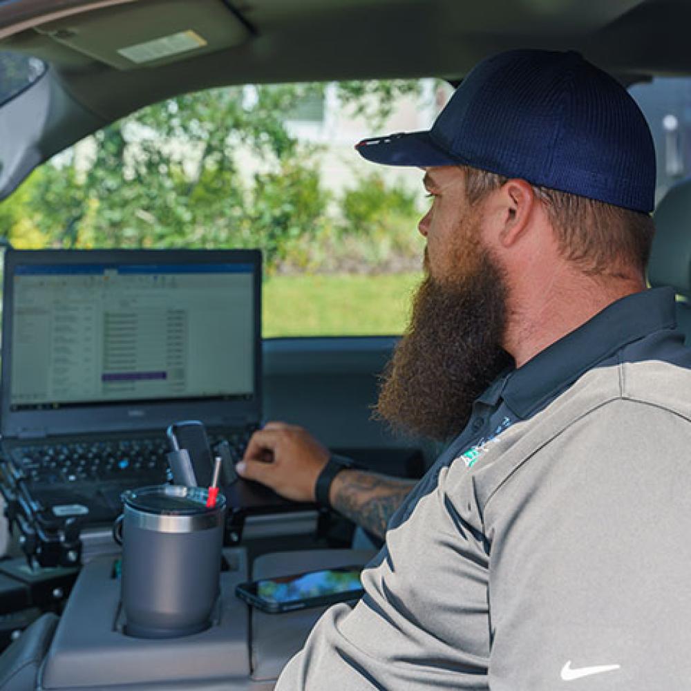 Image of technician viewing computer in vehicle.