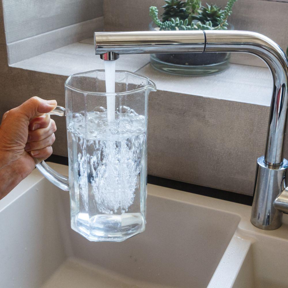 Image of water jug being filled at sink.